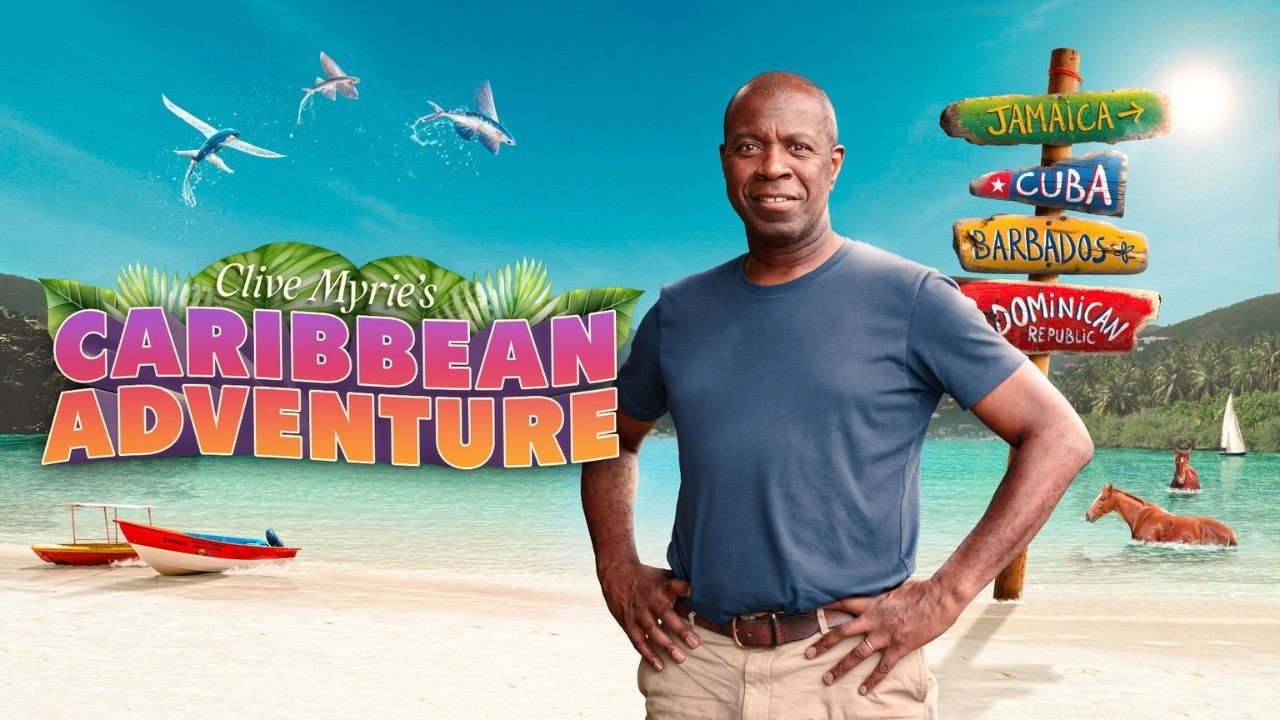 Clive Myrie stood on a beach in the Caribbean