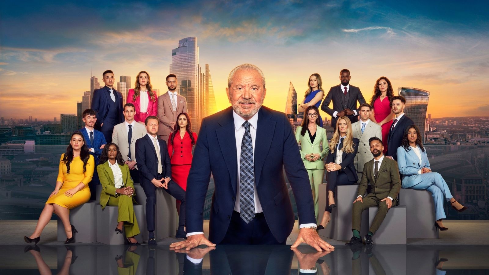 Alan Sugar stood in the centre surrounded by contestants for The Apprentice