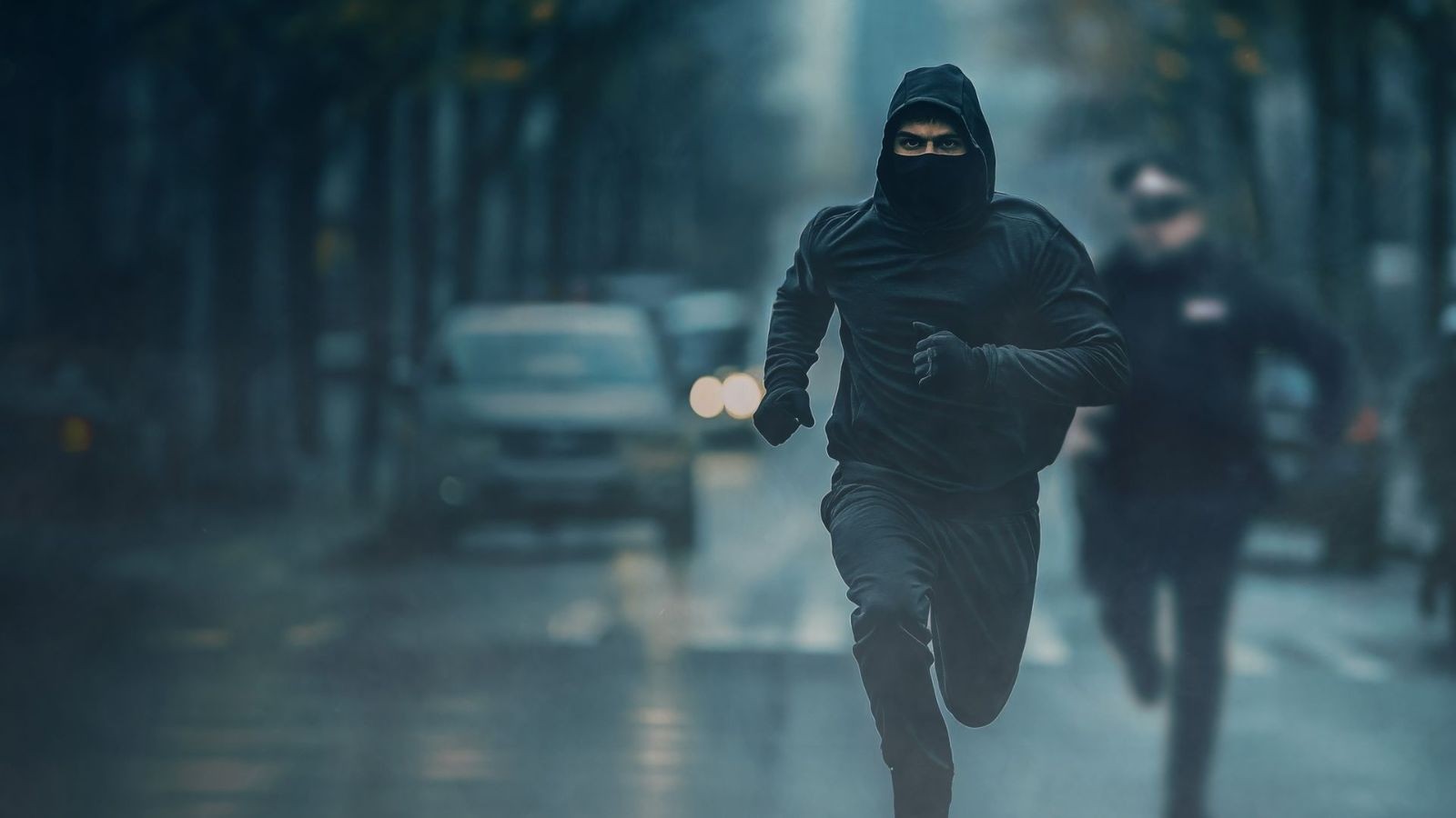 Man with a hood running from the police